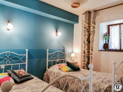 a bedroom with two beds and a blue wall at Montmajou in Cier-de-Luchon