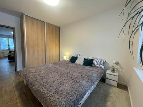 a bedroom with a large bed with green pillows at Modern flat in a city in Humenné