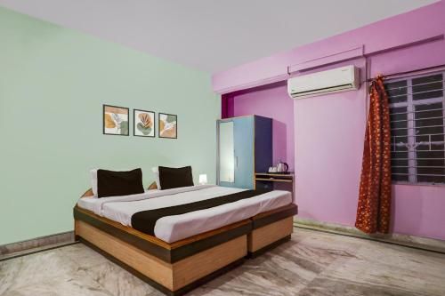 a bedroom with a bed and a purple wall at Super Hotel O Anjanpeer Post Office Hajipur Formerly Hotel New Urvashi in Hājīpur