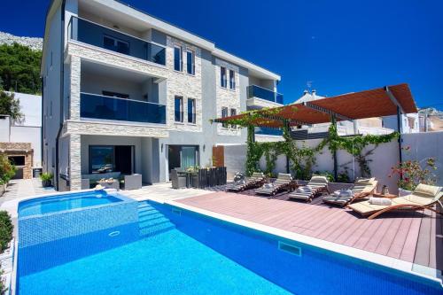 a villa with a swimming pool and a house at LUXURY VILLA PARADISE 120m from sandy beach, heated pool, billiard, max 12 pax in Duće