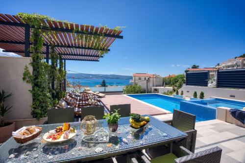 a patio with a table and a swimming pool at LUXURY VILLA PARADISE 120m from sandy beach, heated pool, billiard, max 12 pax in Duće