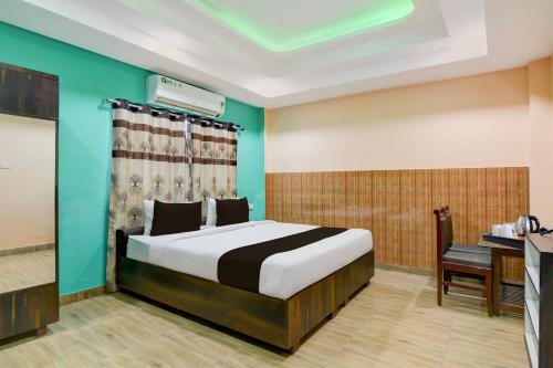 a bedroom with a bed and a desk in a room at Hotel O Eastern Crossway Siliguri Formerly Utsho in Siliguri