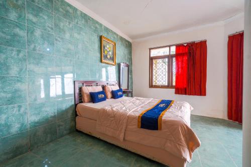 a bedroom with a bed in a room with red curtains at Villa Tjokro 1 By ARBA in Sampal 2