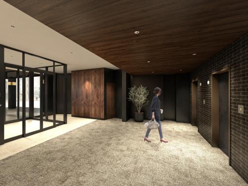 a woman walks through the hallway of a house at Nest hotel alt Sapporo Odori in Sapporo