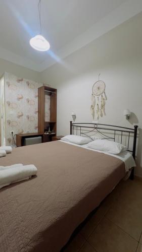 a bedroom with two beds and a clock on the wall at Hotel Trifylia in Kyparissia