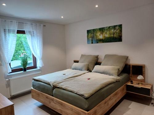 ein Schlafzimmer mit einem großen Bett in einem Zimmer in der Unterkunft Am Wolfsbach in Helferskirchen
