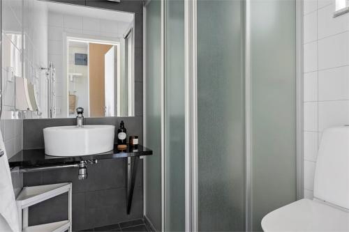 a bathroom with a sink and a mirror at Bella Luna Strandnära in Skummeslövsstrand