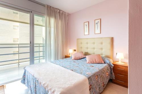 a bedroom with a bed and a large window at Maria apartment in Blanes