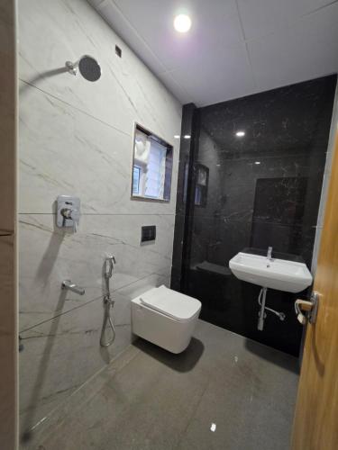 a bathroom with a toilet and a sink at Kovil Vaasam in Tiruchirappalli