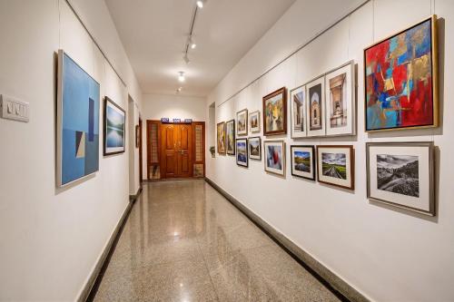 a hallway with a bunch of paintings on the walls at FabHotel Sun Mint - Jubilee Hills in Hyderabad