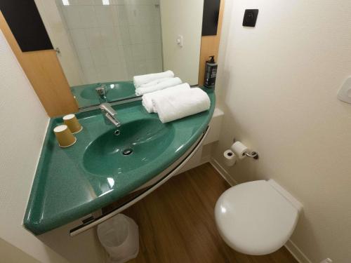 a bathroom with a green sink and a toilet at ibis Lyon Est Bron in Bron