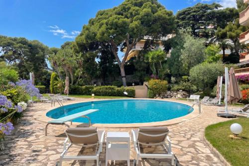 a pool in a resort with chairs and trees at Studio Azur with Sea View Terrace - Happy Rentals in Cap d'Ail
