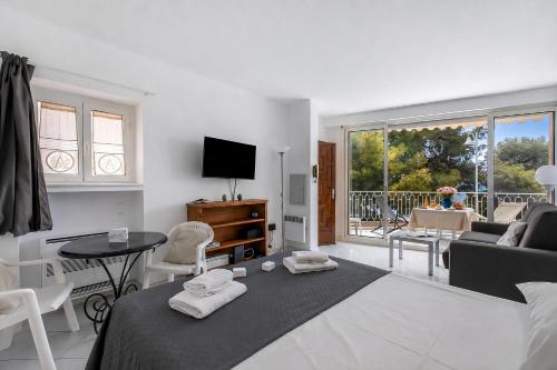 a bedroom with a bed and a living room at Studio Azur with Sea View Terrace - Happy Rentals in Cap d'Ail