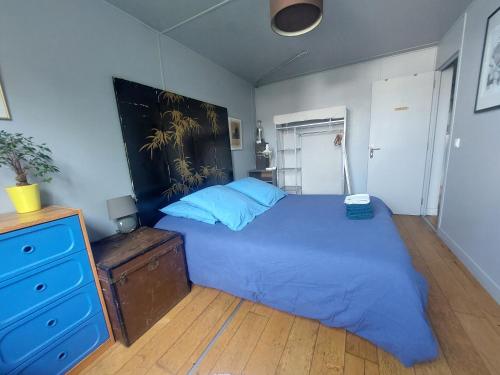 a bedroom with a blue bed and a dresser at Chambres sur Seine Megalight2 in Sèvres