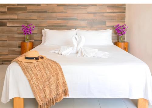 a white bed with a hat on top of it at Centro Mornings, King & 2BR Suites, Sleeps 2-8, Kitchen WiFi AC, Beach, 5th Ave, ADO & Ferry 4 Min in Playa del Carmen