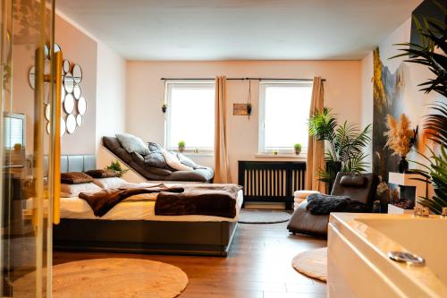 a living room with a bed and a couch at Wellness Suite mit Whirlpool und Sauna in Ahlen