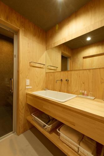 a bathroom with a sink and a large mirror at DEAR MOM - Hotel & Cafe in Onjuku