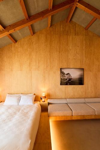 a bedroom with a bed and a couch at DEAR MOM - Hotel & Cafe in Onjuku