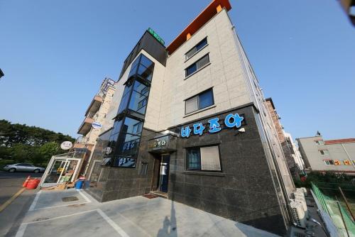 a building with a sign on the front of it at Daecheon Sea Joa Pension in Boryeong