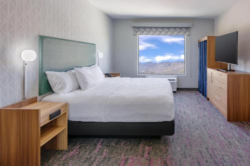 a hotel room with a large bed and a window at Home2 Suites By Hilton Carson City in Carson City
