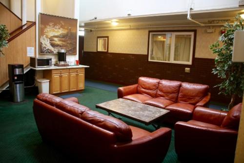 una sala de espera con muebles de cuero y una mesa en Econo Inn en Anchorage