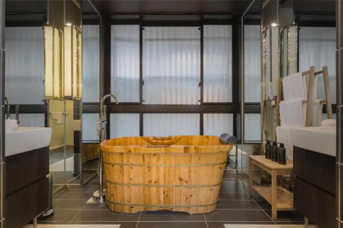 a bathroom with a wooden tub in the middle at Hinode Hills Niseko Village in Niseko