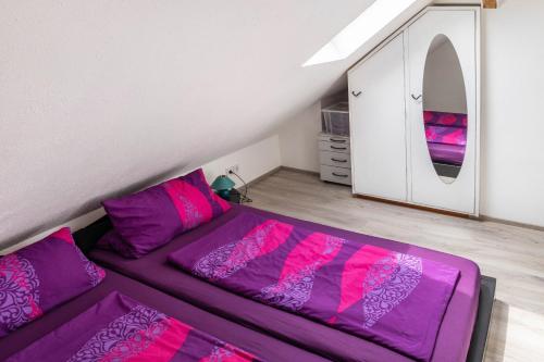 a bedroom with a purple bed and a mirror at A Casa Alfred Kemmern in Kemmern