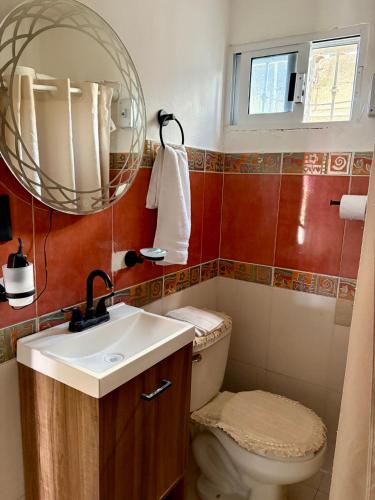 a bathroom with a toilet and a sink and a mirror at Departamento chichan nah in Progreso