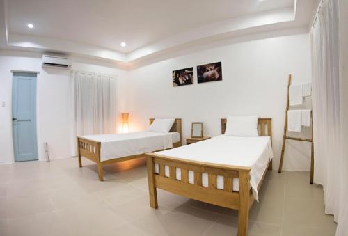 a hotel room with two beds and a room with two beds at El Cielo Resort in Dauin