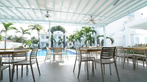 a patio with tables and chairs and a pool at El Cielo Resort in Dauin