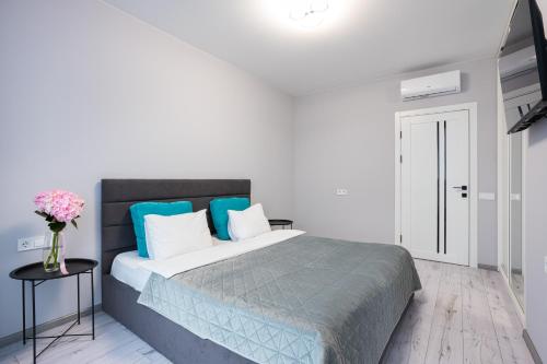 a bedroom with a bed with blue and white pillows at Nyvky Like Home - Fayna Town - apt 149 8 поверх, 1 буд in Kyiv