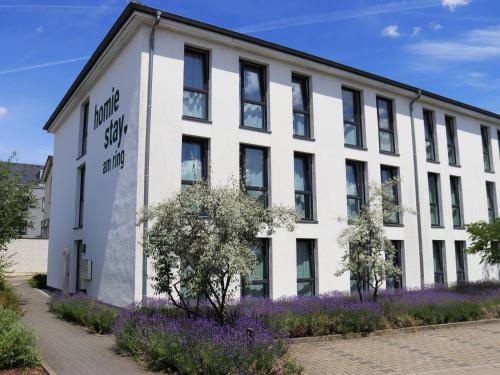 a white building with purple flowers in front of it at homie stay am ring - kostenlose Tiefgarage in Würzburg