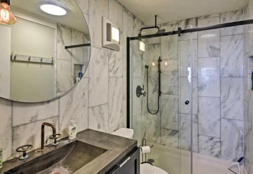 a bathroom with a sink and a shower with a mirror at Beachfront 8th floor Studio - Stunning View in Galveston