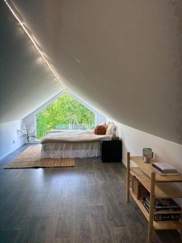a bedroom with a bed and a large window at Halsmo 6 in Kil