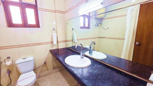 a bathroom with a sink and a toilet and a mirror at Buddha Heritage in Patna