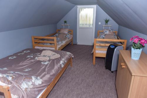 a attic bedroom with two beds and a window at Singh Kuckó Bogács in Bogács