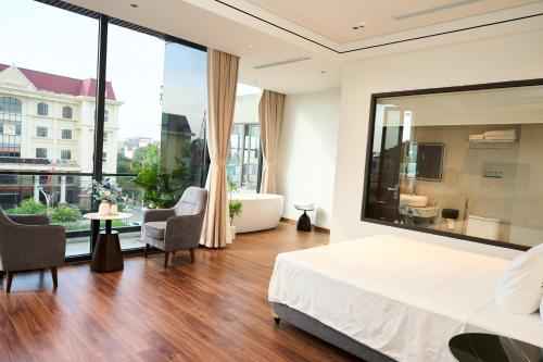 a bedroom with a large bed and a living room at ARIA Hotel in Ninh Binh