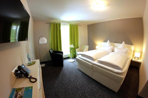 ein Hotelzimmer mit einem Bett und einem Telefon darin in der Unterkunft Hotel Eyberg in Dahn