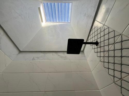 a bathroom with a window and a toilet paper holder at Black Villa Lodge in Hammanskraal