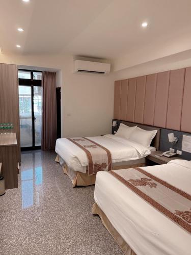 a hotel room with two beds and a window at Jin Zhan Hotel in Jincheng