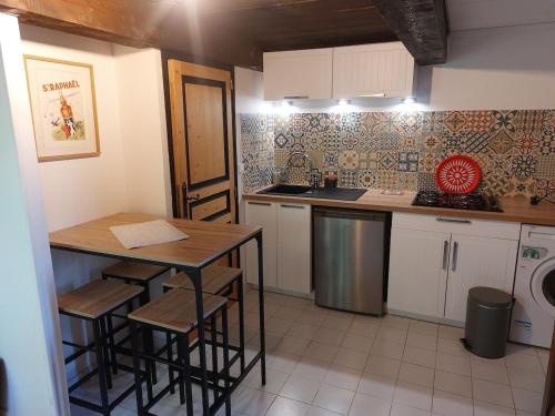 a kitchen with a table and a sink and a stove at Maisonnette de caractère au calme in Fayence