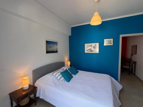 a bedroom with a bed with a blue wall at Art & Motion Union - Guest Room 3 in Apoíkia