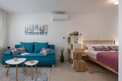 a living room with a blue couch and a bed at Desamani 975 in Kostrena