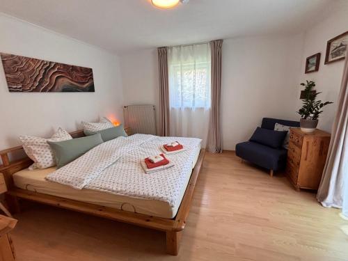 a bedroom with a bed and a blue chair at Haus Auerhahn Ferienwohnungen in Ramsau