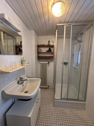 a bathroom with a sink and a shower at Haus Auerhahn Ferienwohnungen in Ramsau