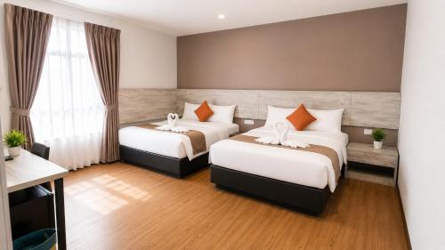 a hotel room with two beds and a window at The Leverage Lite (Kuantan) in Kuantan