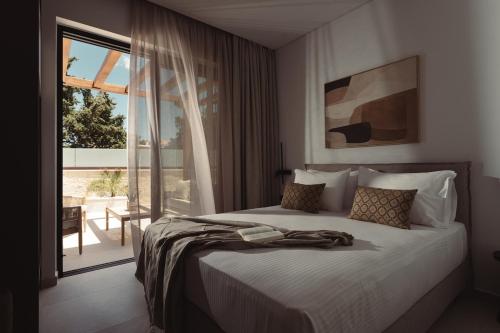 a bedroom with a bed and a large window at Orien, Seaside Luxury Villa in Argassi