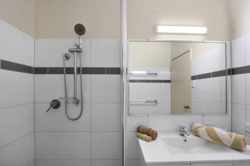 a bathroom with a sink and a shower with a mirror at Pearl Escape in Broome