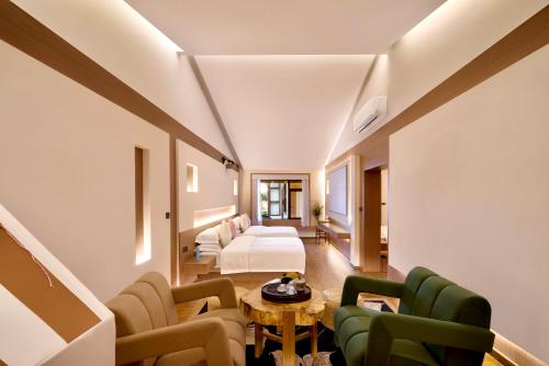 a hotel room with a bed and a table and chairs at 瓦述loft别院 in Zhangjiajie