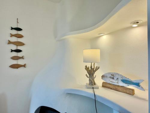 a room with a lamp and a fish on a shelf at Villa Soprana by Agenzia SolturElba in Capoliveri